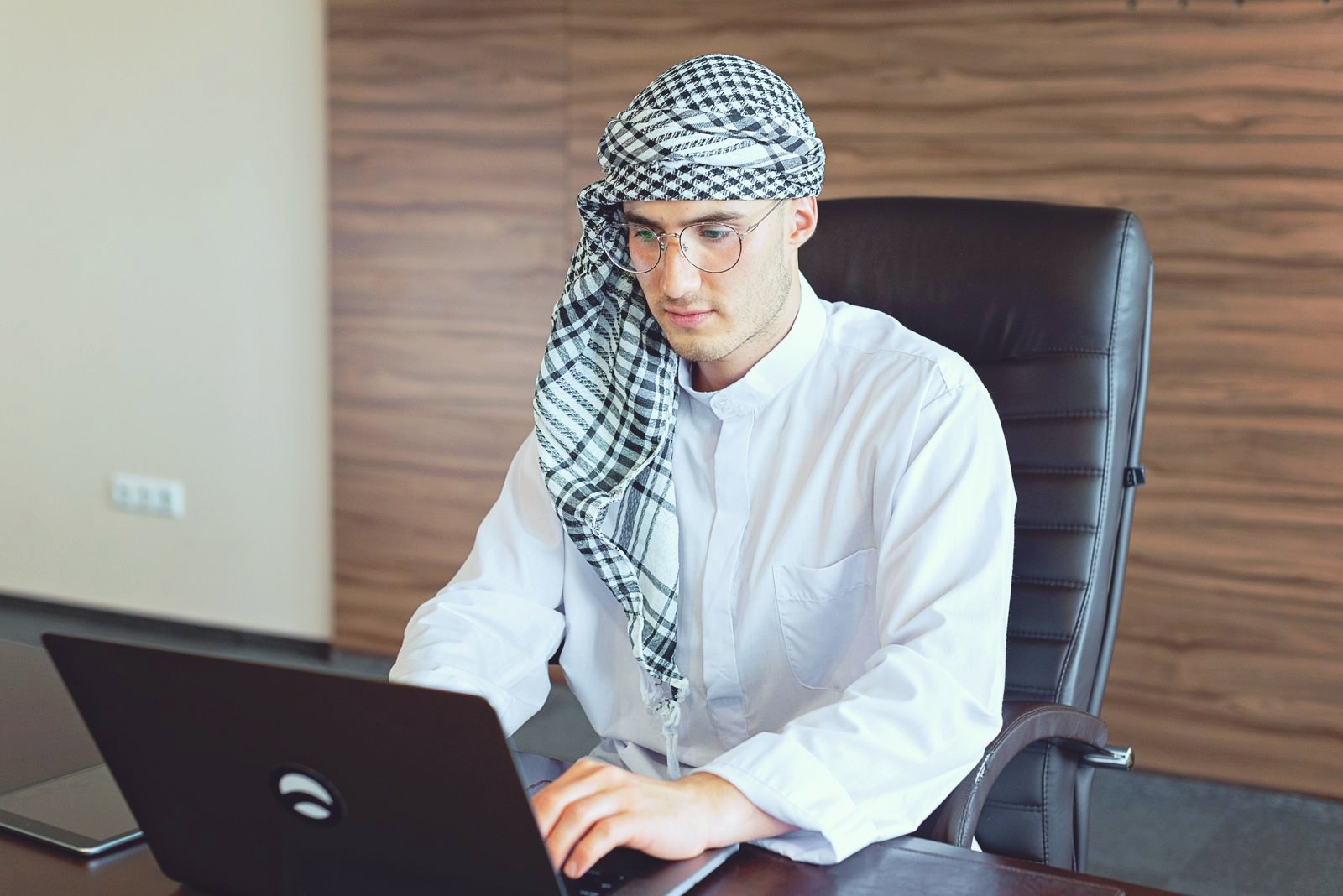 A professional working at a laptop in a modern office